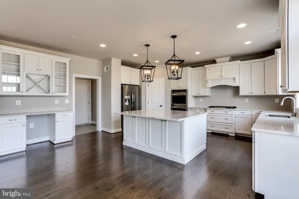 a kitchen with stainless steel appliances sink stove refrigerator and cabinets