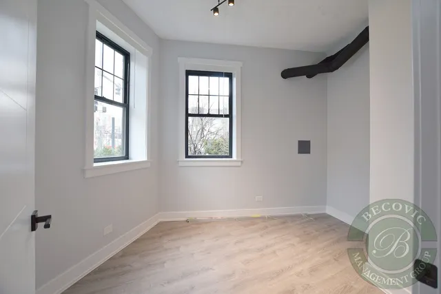 an empty room with window mirror and windows