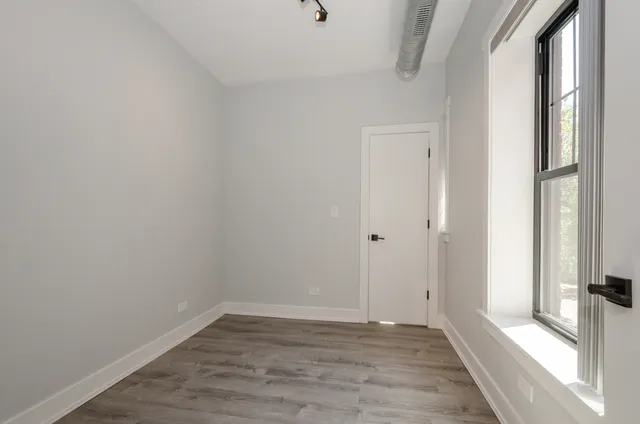 a view of a room with wooden floor and a window
