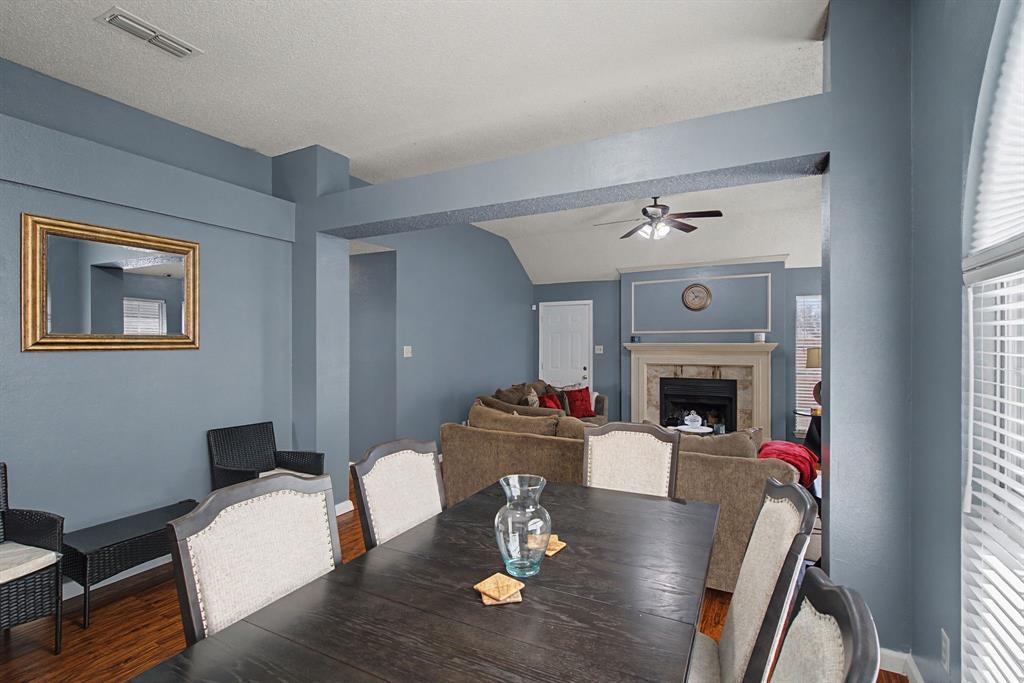645 Cross Ridge Circle Fort Worth, TX 76120 - Photo 12 of 26 Dining area featuring wood finished floors, a premium fireplace, and ceiling fan