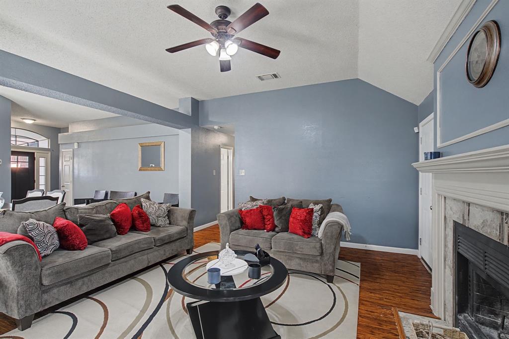 645 Cross Ridge Circle Fort Worth, TX 76120 - Photo 16 of 26 Living room featuring wood finished floors, ceiling fan, and a fireplace