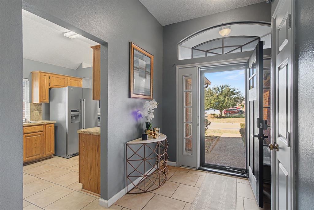 645 Cross Ridge Circle Fort Worth, TX 76120 - Photo 5 of 26 Foyer entrance with a textured wall, a textured ceiling, and light tile patterned flooring