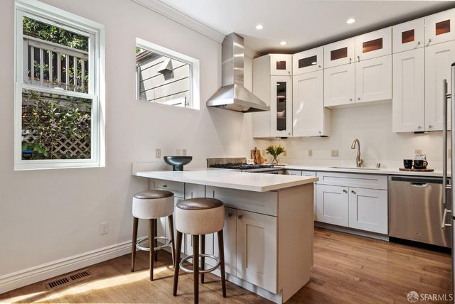a kitchen with stainless steel appliances a stove a sink and a refrigerator