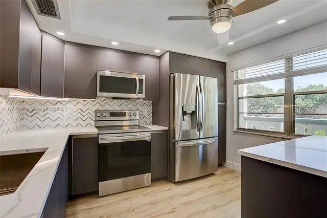 a modern kitchen with stainless steel appliances granite countertop a stove and a refrigerator