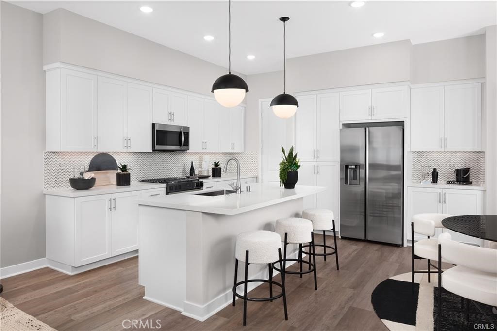 242 Solaro Court Walnut, CA 91789 - Photo 8 of 15 a kitchen with stainless steel appliances a refrigerator a stove a sink a dining table and chairs with wooden floor