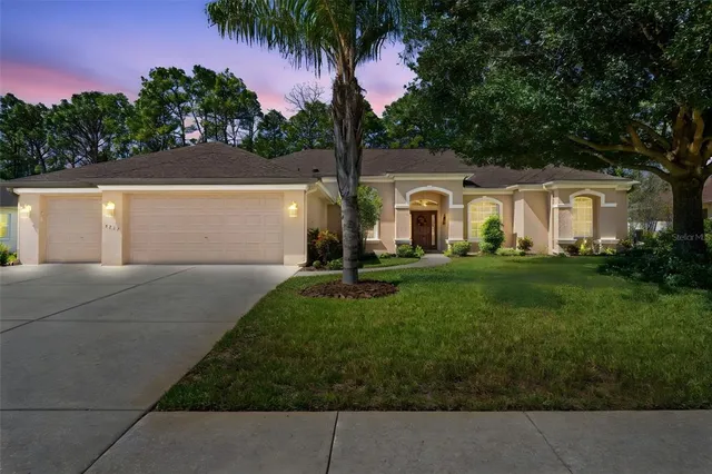 a front view of a house with a garden and tree