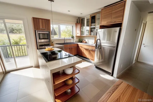 a kitchen with stainless steel appliances a stove a refrigerator a sink a refrigerator wooden floor and cabinets