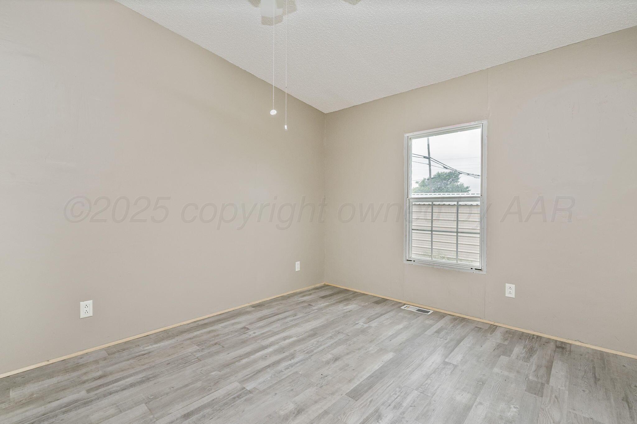 101 Collier Avenue Groom, TX 79039 - Photo 14 of 21 an empty room with wooden floor and windows