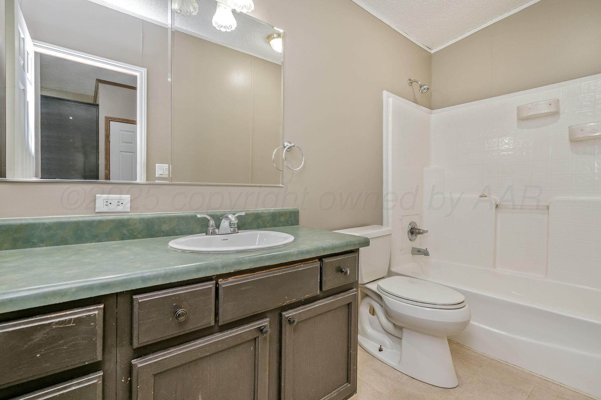 101 Collier Avenue Groom, TX 79039 - Photo 15 of 21 a bathroom with a granite countertop sink toilet and shower