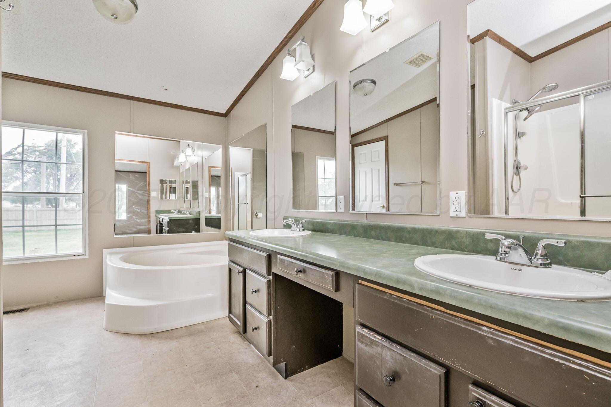 101 Collier Avenue Groom, TX 79039 - Photo 20 of 21 a bathroom with a granite countertop sink mirror and bathtub