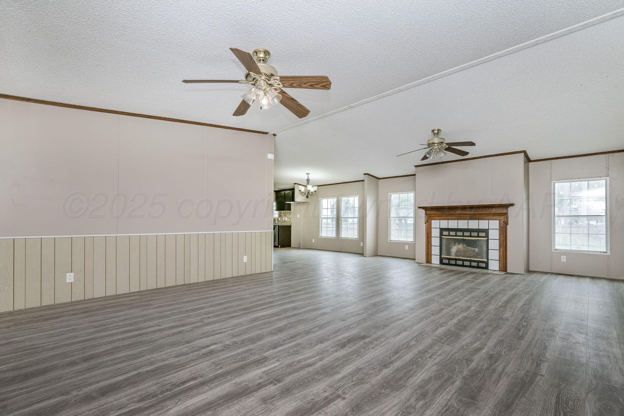101 Collier Avenue Groom, TX 79039 - Photo 5 of 21 a view of an empty room with wooden floor fireplace and a window