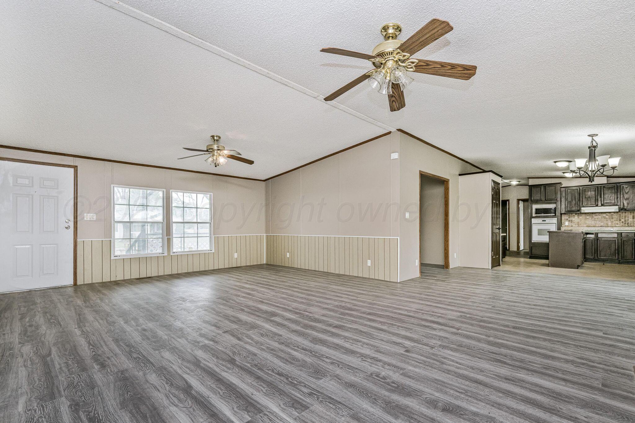 101 Collier Avenue Groom, TX 79039 - Photo 6 of 21 a view of an empty room with a window and wooden floor