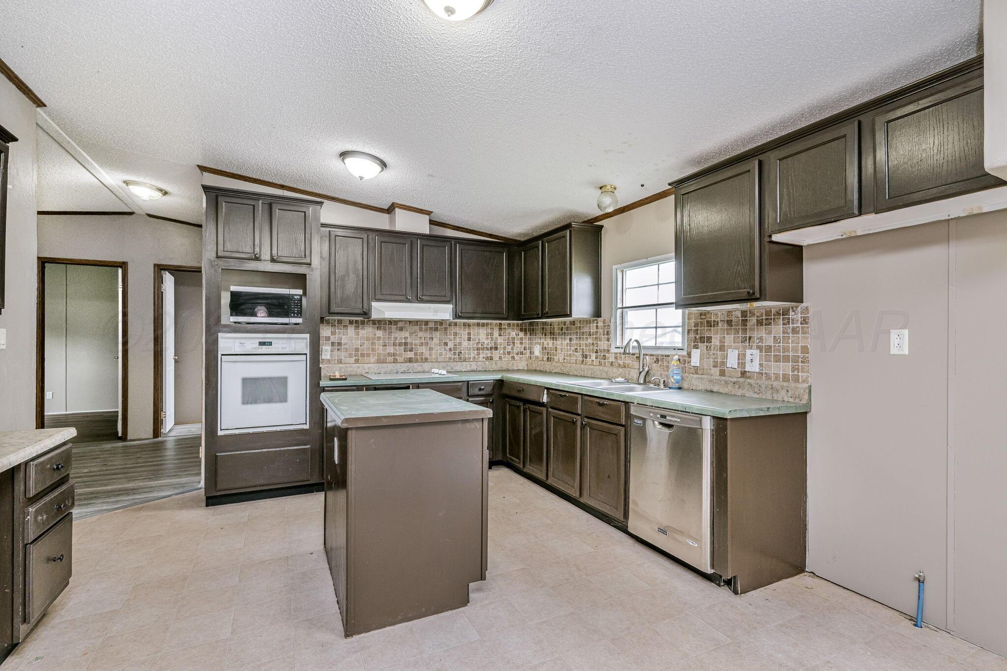 101 Collier Avenue Groom, TX 79039 - Photo 9 of 21 a kitchen with stainless steel appliances granite countertop a refrigerator and a stove top oven