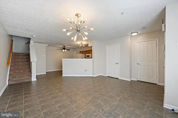 a view of a room with stairs and a chandelier