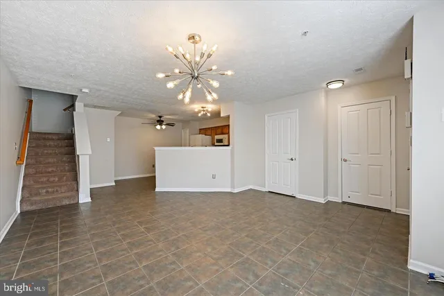 a view of a room with stairs and a chandelier