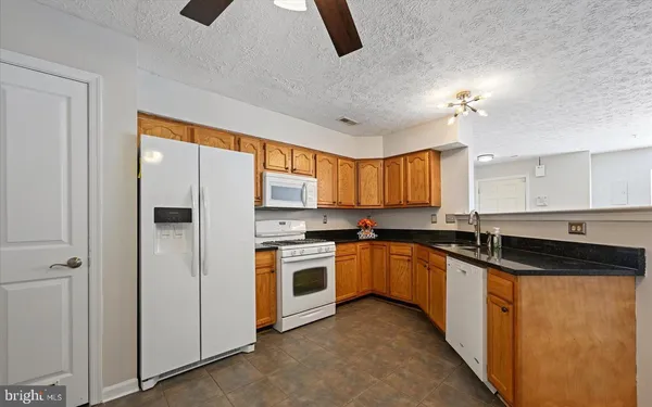 a kitchen with granite countertop a sink stove and cabinets