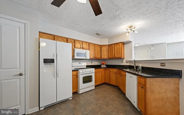 a kitchen with granite countertop a sink stove and cabinets