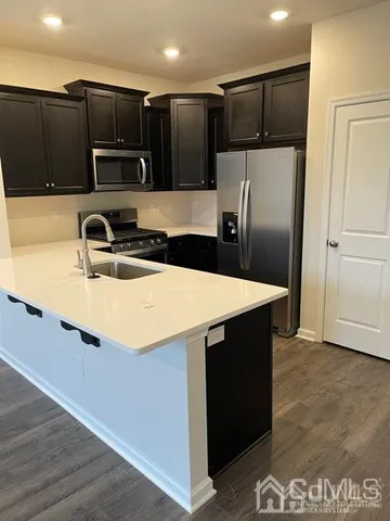 a kitchen with kitchen island a refrigerator sink and microwave