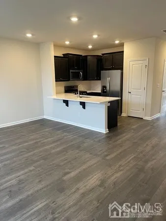 a view of kitchen with microwave and white cabinets
