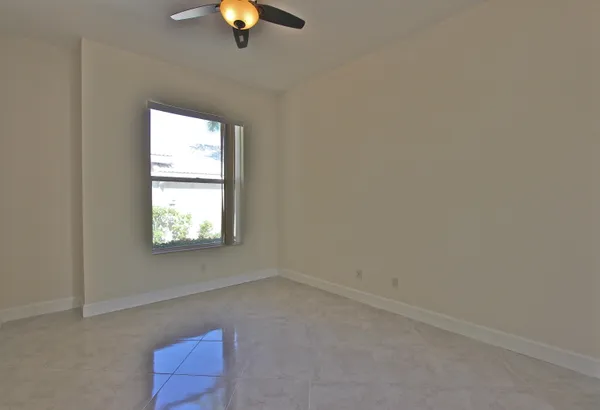 an empty room with a ceiling fan and glass door