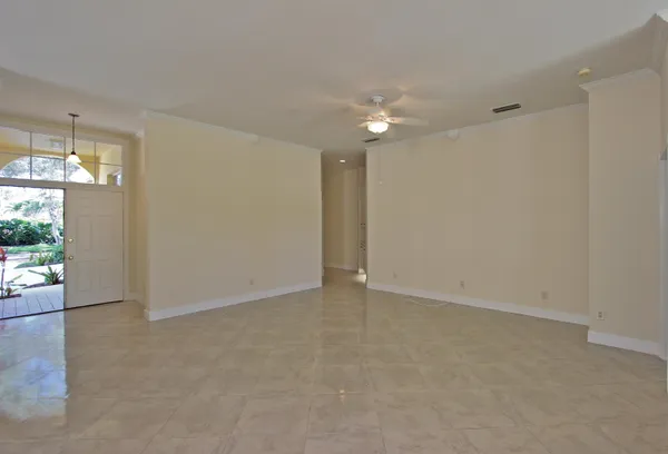 a view of an empty room with a chandelier fan