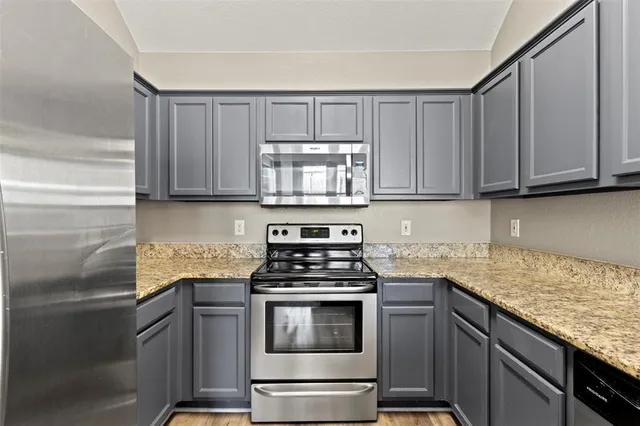 a kitchen with granite countertop wood cabinets and stainless steel appliances