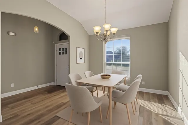 a view of a dining room with furniture wooden floor and chandelier