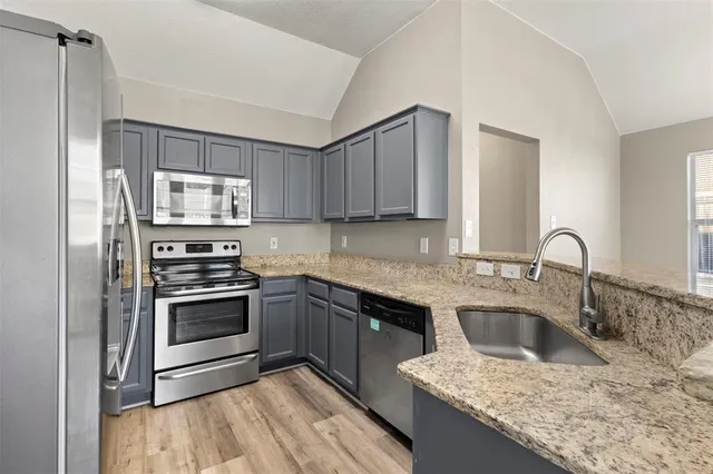 a kitchen with stainless steel appliances granite countertop a sink stove and refrigerator