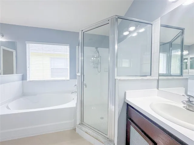 a bathroom with a tub shower and sink