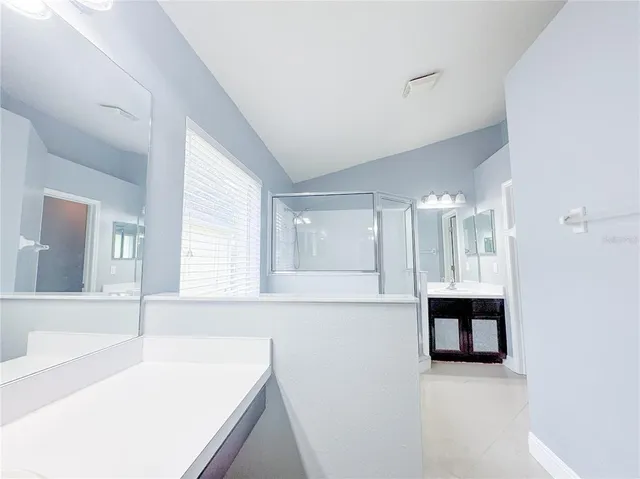 an empty room with chandelier fan and windows