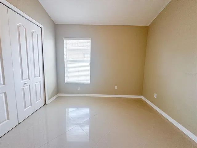 an empty room with a ceiling fan and carpet