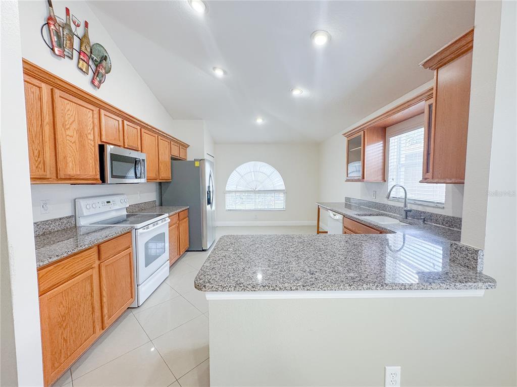 4150 Branchside Lane Wesley Chapel, FL 33543 - Photo 8 of 32 a kitchen with stainless steel appliances granite countertop a sink stove and microwave