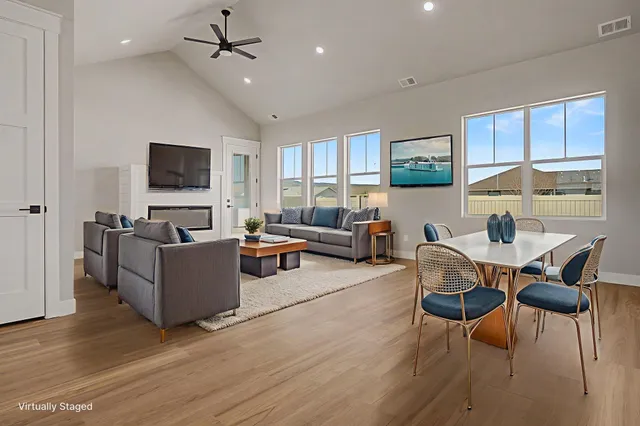 a living room with furniture a flat screen tv and wooden floor