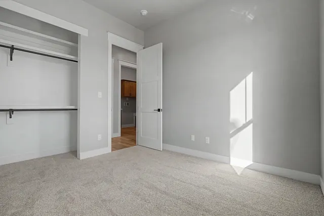 an empty room with windows and closet