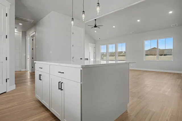a kitchen with kitchen island white cabinets and refrigerator