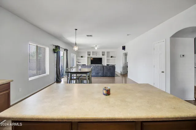 a large white kitchen has a large counter space and stainless steel appliances
