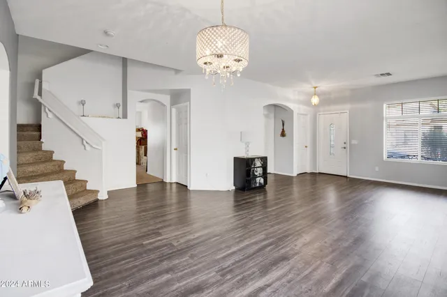 a view of an empty room with wooden floor and a fireplace