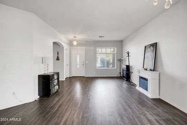 an empty room with wooden floor and fireplace
