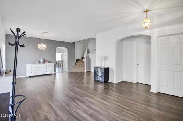 a view of a room with wooden floor and a kitchen