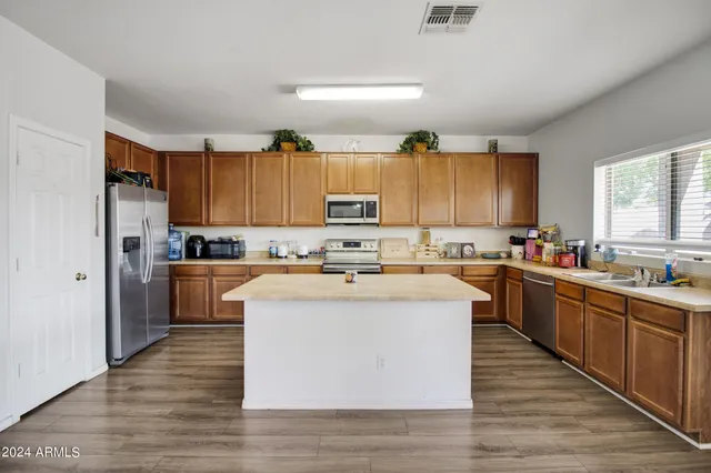a kitchen with stainless steel appliances granite countertop a stove top oven a sink dishwasher and a refrigerator