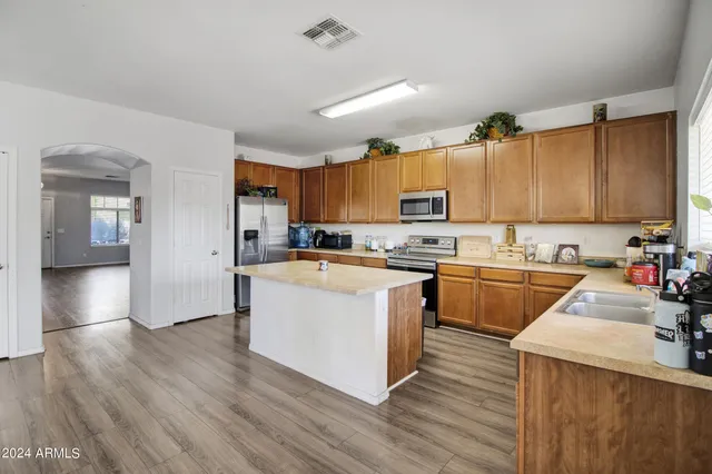 a large kitchen with stainless steel appliances granite countertop a stove a sink dishwasher and a refrigerator