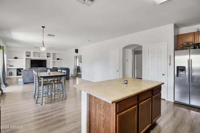 a kitchen with a table chairs refrigerator and cabinets