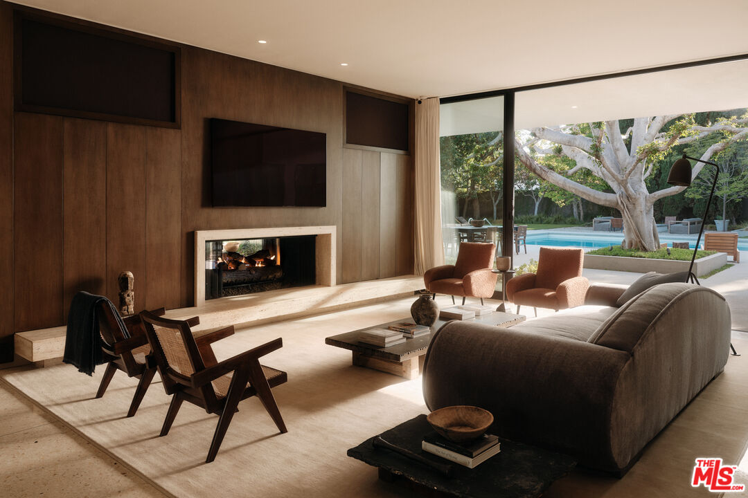 713 North Hillcrest Road Beverly Hills, CA 90210 - Photo 13 of 28 a living room with furniture a flat screen tv and a fireplace
