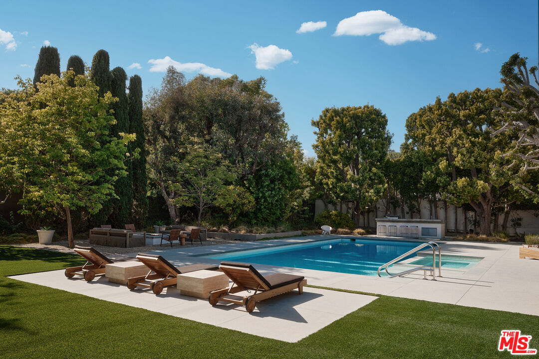 713 North Hillcrest Road Beverly Hills, CA 90210 - Photo 16 of 28 a view of a swimming pool and lounge chairs