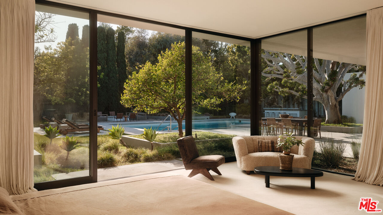 713 North Hillcrest Road Beverly Hills, CA 90210 - Photo 19 of 28 a living room with couch and a floor to ceiling window