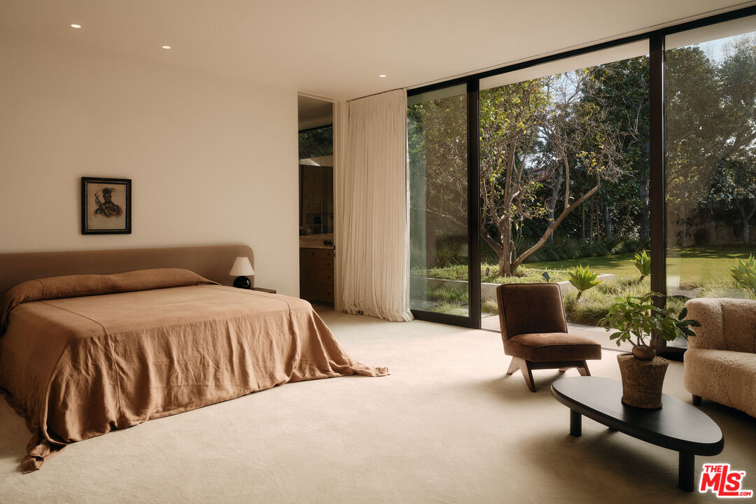 713 North Hillcrest Road Beverly Hills, CA 90210 - Photo 20 of 28 a bedroom with a bed and glass window