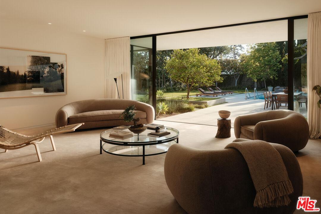 713 North Hillcrest Road Beverly Hills, CA 90210 - Photo 6 of 28 a living room with furniture and a large window