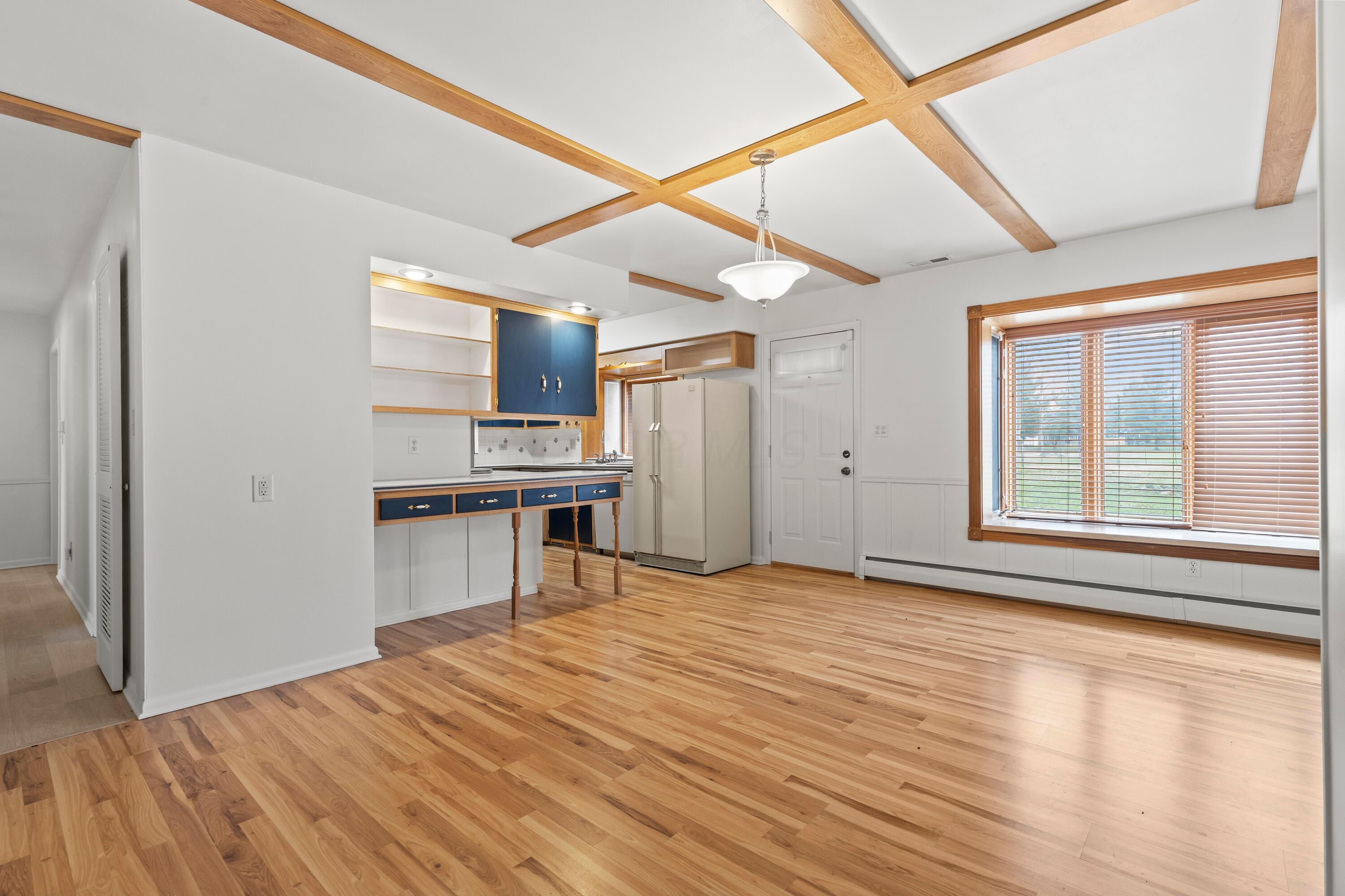 6982 Lee Road Westerville, OH 43081 - Photo 15 of 71 • New vinyl flooring ~ 2020/2021 • White painted walls • Chandelier • Box window with seat • Door to patio • Planning desk • 2” blinds