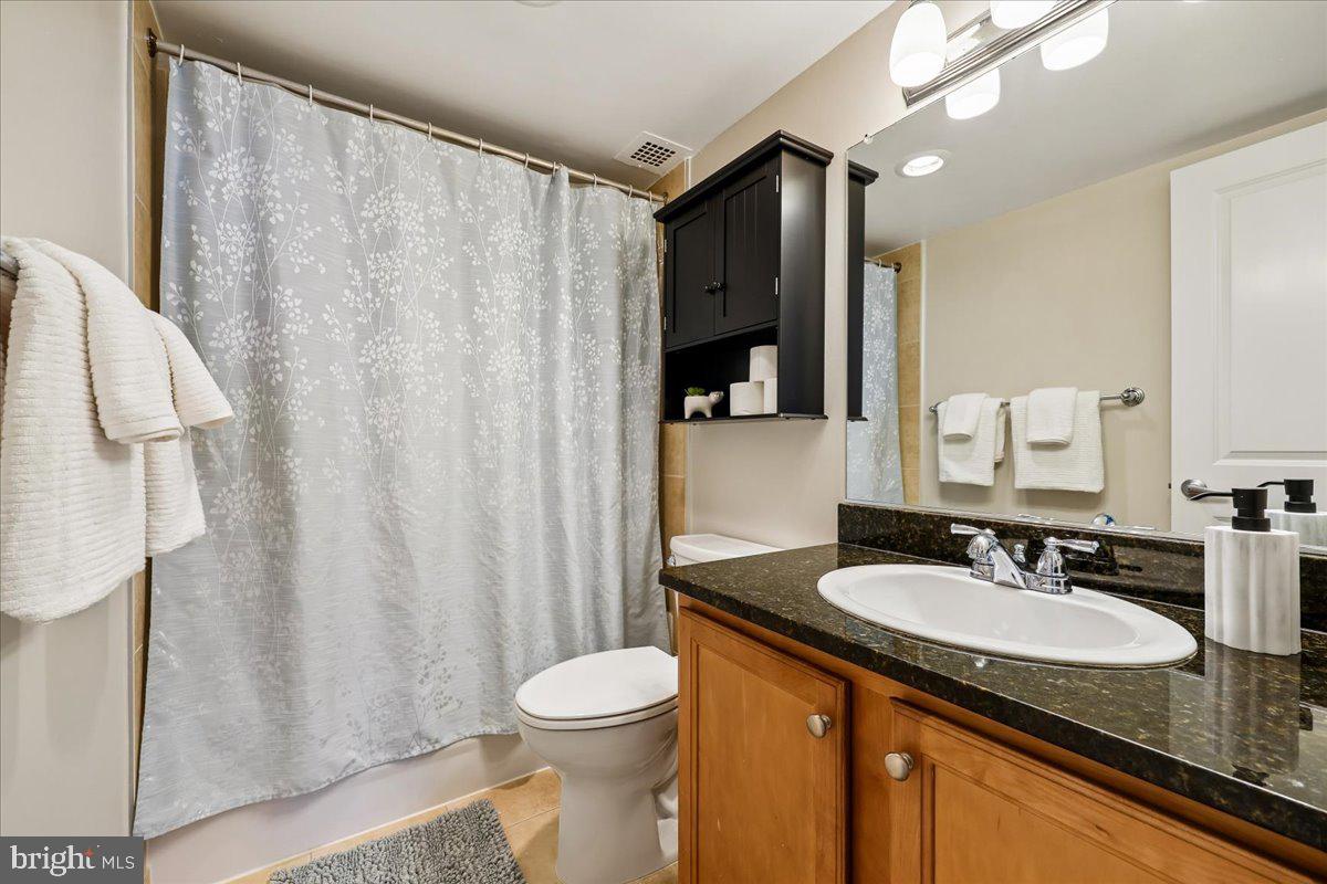 1220 Blair Mill Road, Unit 804 Silver Spring, MD 20910 - Photo 11 of 18 a bathroom with a granite countertop sink and a mirror