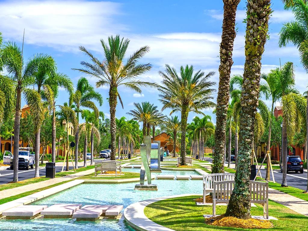 9114 Capistrano Street South, Unit 8501 Naples, FL 34113 - Photo 15 of 26 a view of a swimming pool with a lawn chairs and palm tree